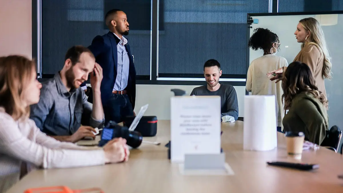 arquitetura de dados para seguradoras: Reunião em escritório com profissionais discutindo um projeto, usando apresentações e documentos sobre uma mesa. Cenas de colaboração e planejamento em equipe.